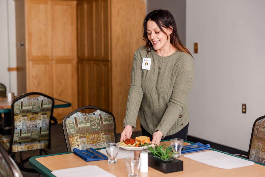 Dining Team Member Serving a Meal | Pelican Valley Senior Living