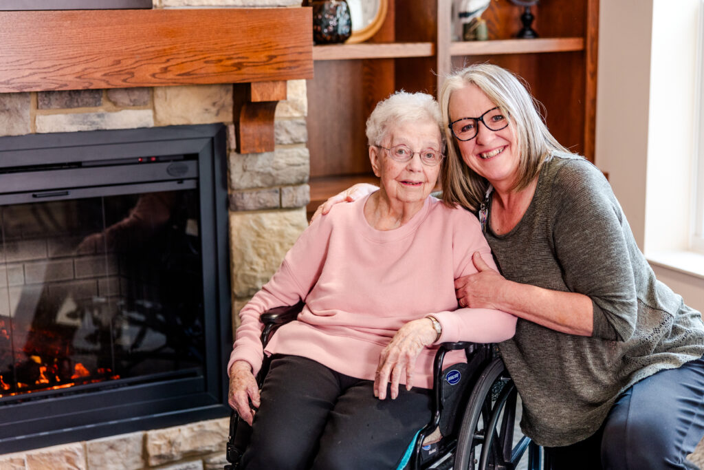 A Team Member with Her Arm Around a Resident, Smiling | Pelican Valley Senior Living