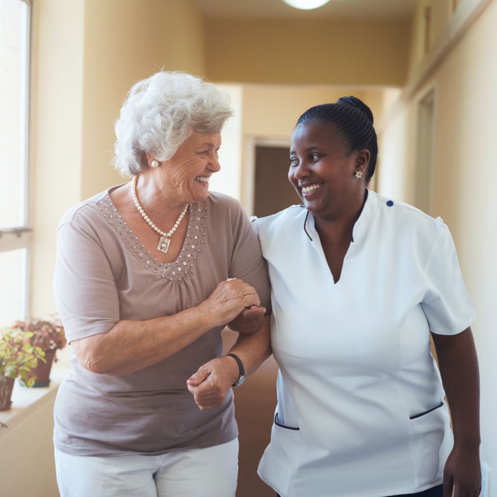 Nurse and Resident Walking Together, Smiling at Each Other | Pelican Valley Senior Living