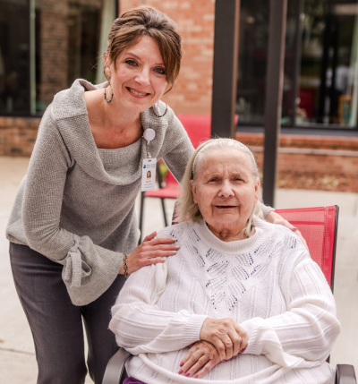 Team Member Smiling with Resident Outside | Pelican Valley Senior Living