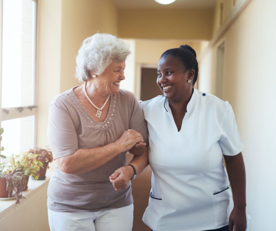 Nurse and Resident Walking Together, Smiling at Each Other | Pelican Valley Senior Living